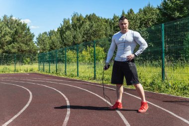 bir atlama ipi ile stadyumda atletik adam. Sağlıklı yaşam tarzı.