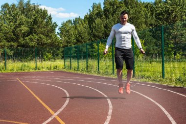 bir atlama ipi ile stadyumda atletik adam. Sağlıklı yaşam tarzı.