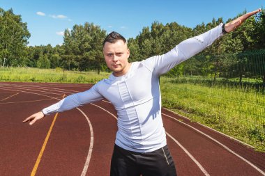 fitness, spor, egzersiz ve yaşam tarzı kavramı - atlet spor stadyumunda duruyor ve kameraya bakar.