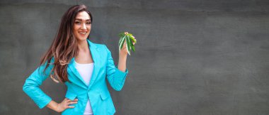 Kız elinde bir kenevir yaprağı tutar ve gülümsüyor. Kavramsal fotoğraf