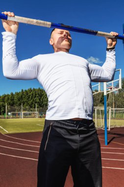 Spor, sokak egzersiz kavramı - çekme işi atlet yatay ups açık havada bar.