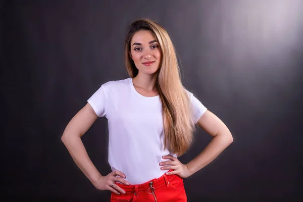 Młoda Dziewczyna Białej Koszulce Czerwonych Dżinsach Czarnym Tle Uśmiechnięta Dziewczyna — Zdjęcie stockowe
