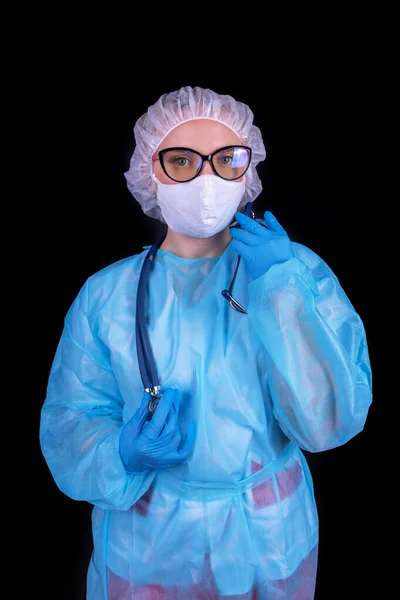 A nurse on a black background in a protective uniform.