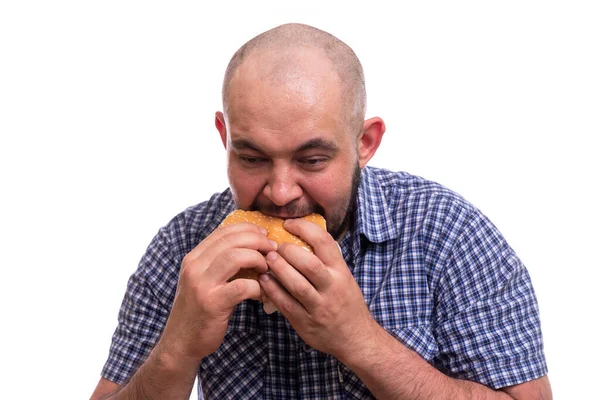 Homem Careca Morde Gananciosamente Hambúrguer Isolado Fundo Branco — Fotografia de Stock