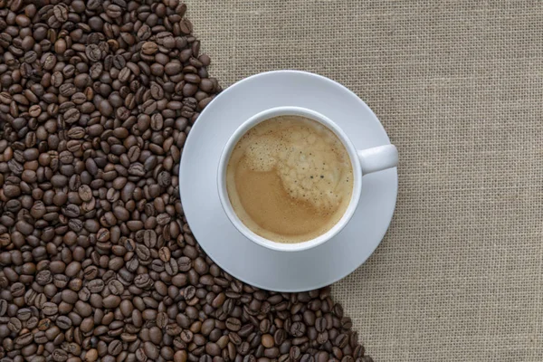 Taza de café con saco de arpillera de frijoles asados —  Fotos de Stock