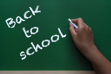 Afrikalı-Amerikalı kadın mektup geri okula beyaz tebeşir yeşil bir kara tahta yazma