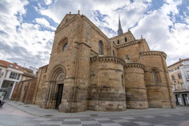 Benavente, Zamora, Spain, June 2017: Romanesque facade with five semicircular apses and tower, show some of different architectural styles found in Church of Santa Maria del Azogue of Benavente  clipart