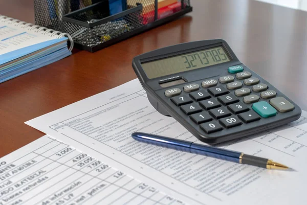 電卓とビジネスマンの机の上の財務報告書 — ストック写真