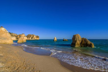 Portekiz Algarve bölgesinde yalnız bir sahilde günbatımı