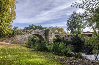 Medieval bridge over Arnoia river in Allariz, Ourense, Spain, in autumn clipart