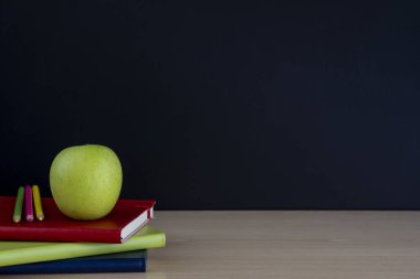 kitap kalemler ve okul için boş yazı tahtası ile yeşil elma