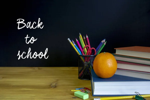 回到学校的概念 学校用品 和一个橙色在黑板前 选择性重点 — 图库照片