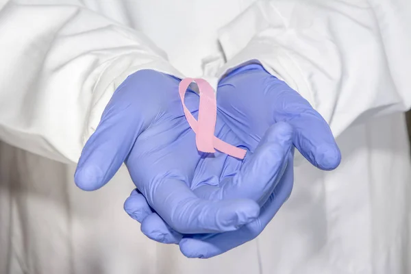 肿瘤疾病的概念 医生穿着白色大衣和听诊器在手套把粉红色丝带作为乳腺癌的象征 — 图库照片