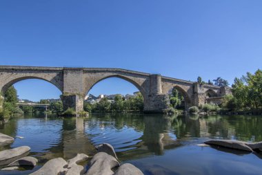 Roman bridge over the river Mino as it passes through the city of Ourense clipart
