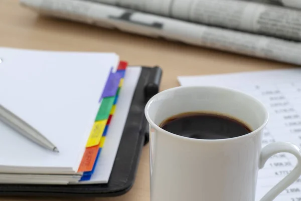 Kopje geurende koffie op een ochtend papier zakelijk nieuws — Stockfoto