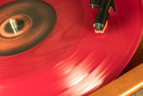 A red vinyl disc is spinning in the music player