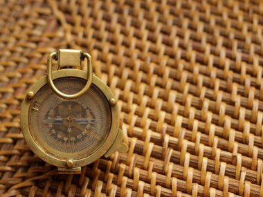 Gemi cihazları ve navigasyon konsepti. Gemi pusulası bej hasır masada yatıyor.