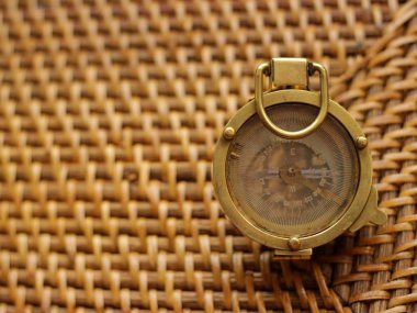 Gemi cihazları ve navigasyon konsepti. Gemi pusulası bej hasır masada yatıyor.