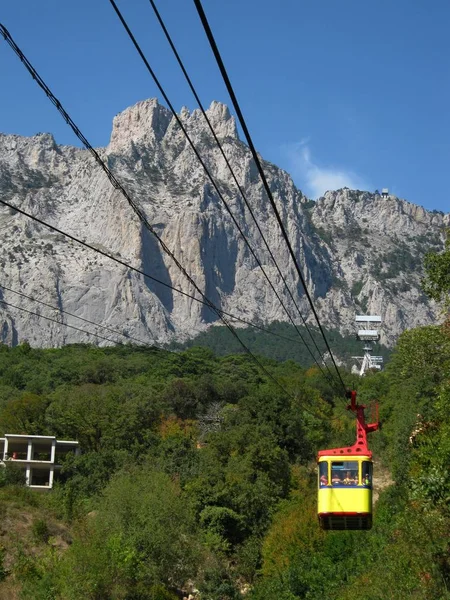 Seyahat ve turizm konsepti. sarı kablo yolu yüksek bir dağa tırmanıyor. teleferik ile peyzaj