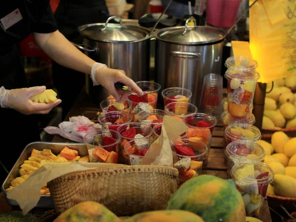 Sağlıklı beslenme ve gıda konsepti. Vietnam restoranında pideli meyve bardakları. Şef farklı renklerde ejderha meyve bir salata hazırlar. Pişirme gereçleri ve tropikal meyveler çevresinde.