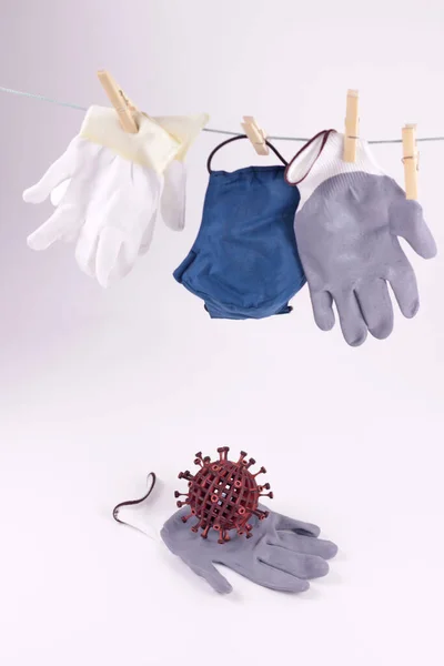 Personal protective equipment in time coronavirus pandemic concept.Clean mask and gloves hang dry on clothesline.white background.Selective focus.Copy space for text