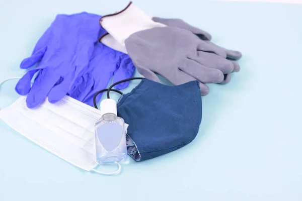 Personal protective equipment in time coronavirus pandemic concept.Health protection equipment such as mask,gloves and sanitizer close up on blue background.Selective focus.Copy space for text