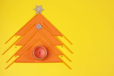 Sarı arka planda yaratıcı Noel ağacı, turuncu mutfak aletleri kağıt peçeteler ve kuyruk tüplerinden yapılmış. Yeni yıl kavramınız kutlu olsun. Kopya alanı olan tebrik kartı. Fotokopi alanı olan düz uzanmış..