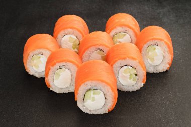 Siyah arka plan üzerine Japon deniz ürünleri suşi rulo