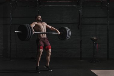 Kaslı adam crossfit spor salonunda bir halter kaldırma.
