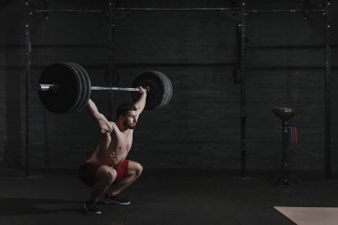 Genç crossfit atlet spor salonunda halter ek yük kaldırma. Kopya alanı
