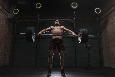 Genç crossfit atlet spor salonunda ağır halter kaldırma. Powerlifting pratik.