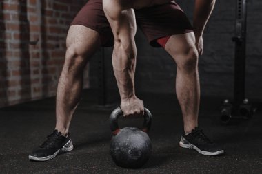 Crossfit atlet spor salonunda bir kettlebell ile egzersiz. Fonksiyonel eğitim yapan yakışıklı erkek. Pratik egzersiz