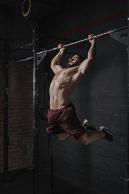 Genç crossfit atlet pull-up spor yapıyor. Fonksiyonel eğitim yapan yakışıklı erkek. Jimnastik pratik.