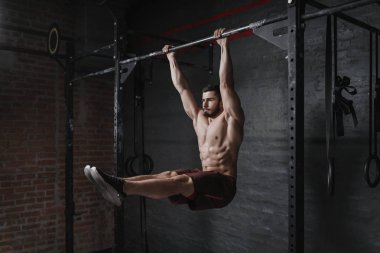 Crossfit atlet spor yatay çubuk ABS egzersiz yapıyor. Fonksiyonel eğitim egzersiz yapan yakışıklı erkek. Jimnastik pratik.