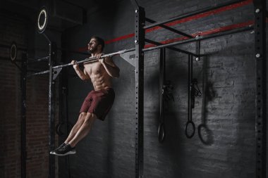Crossfit atlet pull-up spor yapıyor. Jimnastik pratik. Fonksiyonel eğitim yapan yakışıklı erkek.