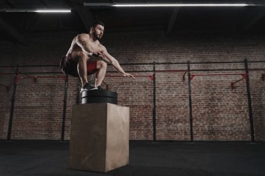 CrossFit atlet spor salonunda kutusunu atlamak gerçekleştiriyor. Fonksiyonel eğitim yapan yakışıklı erkek. Egzersiz Egzersizler. Kopya alanı