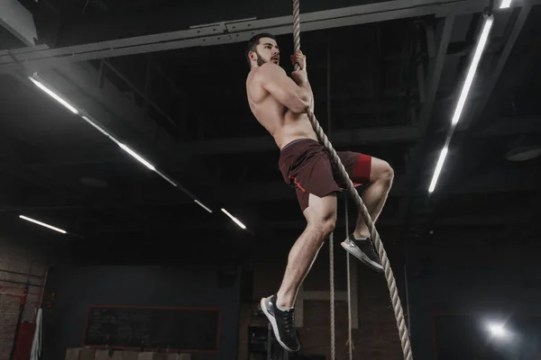 Νέοι Crossfit Αθλητής Αναρρίχηση Ένα Σχοινί Στο Γυμναστήριο Όμορφος Άντρας — Φωτογραφία Αρχείου
