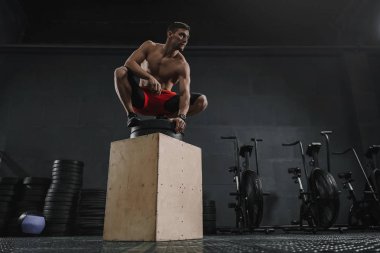 Sportif delikanlı kutusunu atlamak sonra spor salonunda egzersiz dinlenme