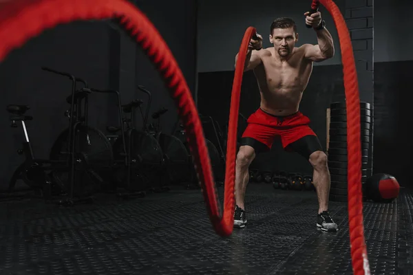 Exercício de cordas de batalha durante o treinamento crossfit no ginásio — Fotografia de Stock