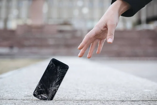 Genç kadının yakın çekim onu kırık akıllı telefon zekâ uzanır