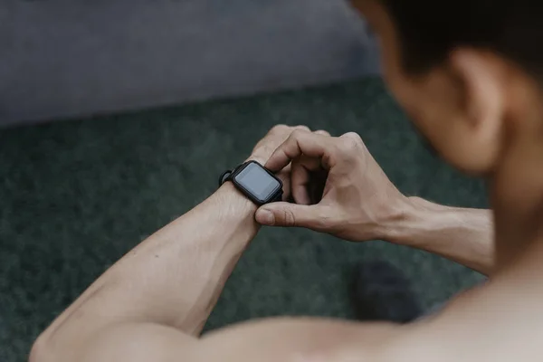 Athlete looking at his smartwatch fitness app after workout