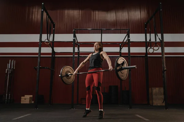 Crossfit femme soulevant haltère lourd à la salle de gym . — Photo