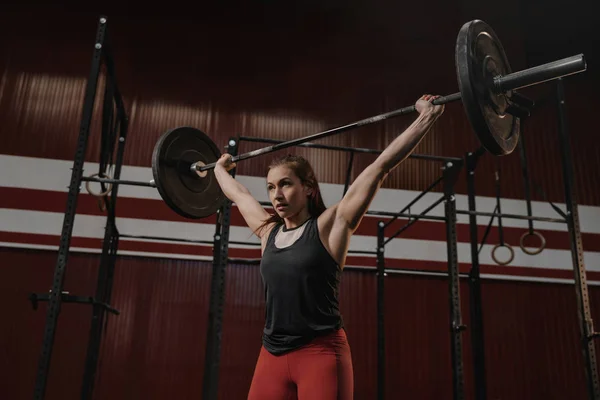 Young muscular woman doing weightlifting exercises at crossfit g — 스톡 사진