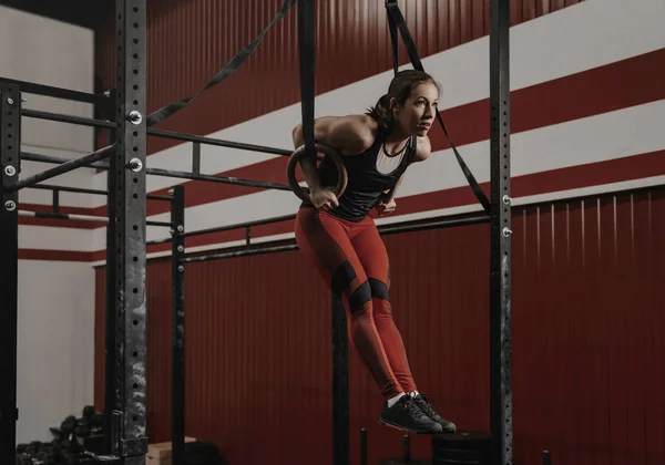 Young crossfit woman doing muscle-ups on gymnastic rings at the — 스톡 사진