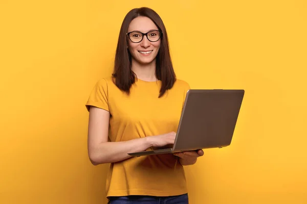 Jonge Leuke Vrouw Bril Lacht Gelukkig Houdt Laptop Geïsoleerd Gele — Stockfoto