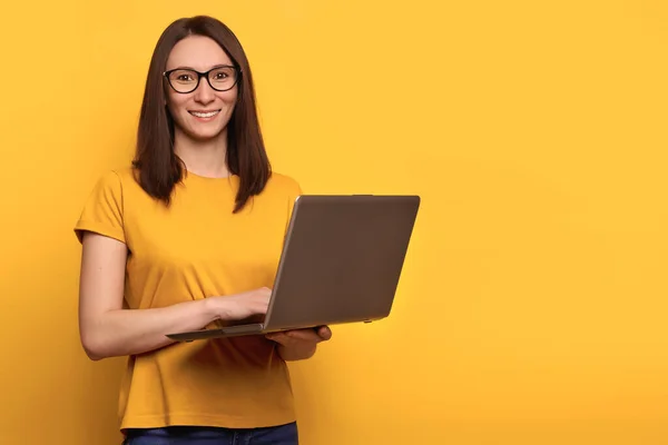 Jonge Leuke Vrouw Bril Lacht Gelukkig Houdt Laptop Geïsoleerd Gele — Stockfoto