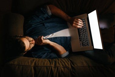 Genç iş adamı ya da serbest çalışan evde dizüstü bilgisayarla fazla mesai yapan, gece geç saatlere kadar kanepede yatan, uyuyamayan, son teslim tarihi olan biri. Uykusuzluk ve bilgisayar bağımlılığı. Fazla çalışma ve uzak çalışma kavramı