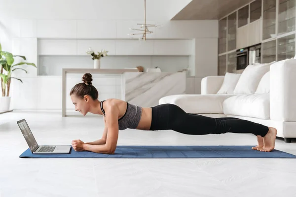 Vacker Ung Kvinna Sport Uniform Gör Planka Motion Vardagsrummet Hemma — Stockfoto