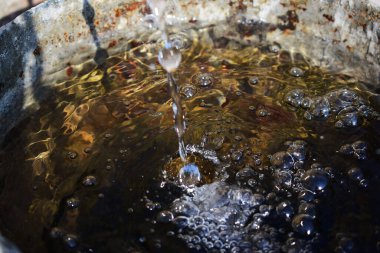 akan su kabarcıklı bir su kabına dökülüyor.