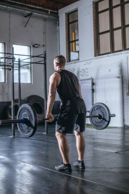 Arkadan görünüşü sporcu spor salonunda ağırlık kaldırma.